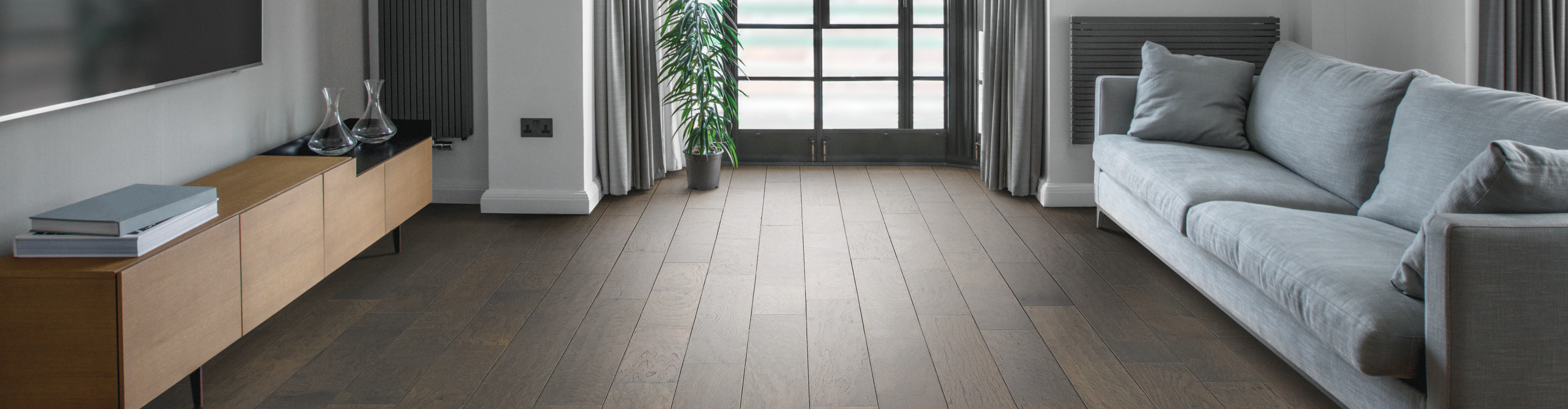 Light wide plank hardwood entryway with  bench and green accents 